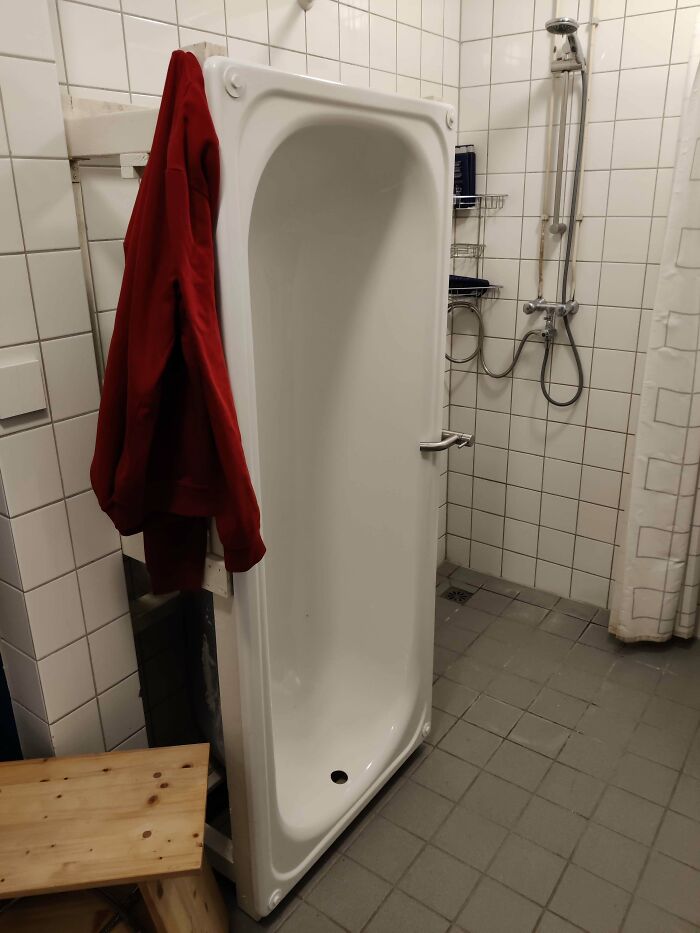 Bathtub repurposed and standing vertically in bathroom showcasing unusual DIY projects and creative DIY ideas.