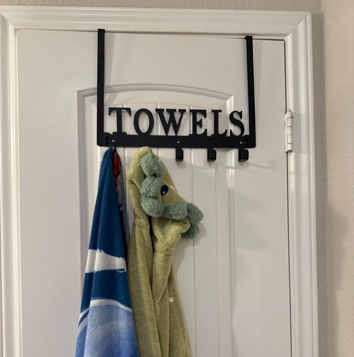 Black metal towel rack hanging on a white door with towels, an Amazon find popular on wishlists right now.