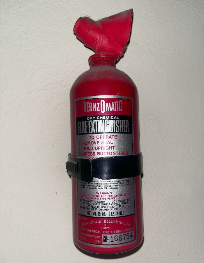 Vintage dry chemical fire extinguisher mounted on wall, showcasing how things used to look with classic safety equipment.