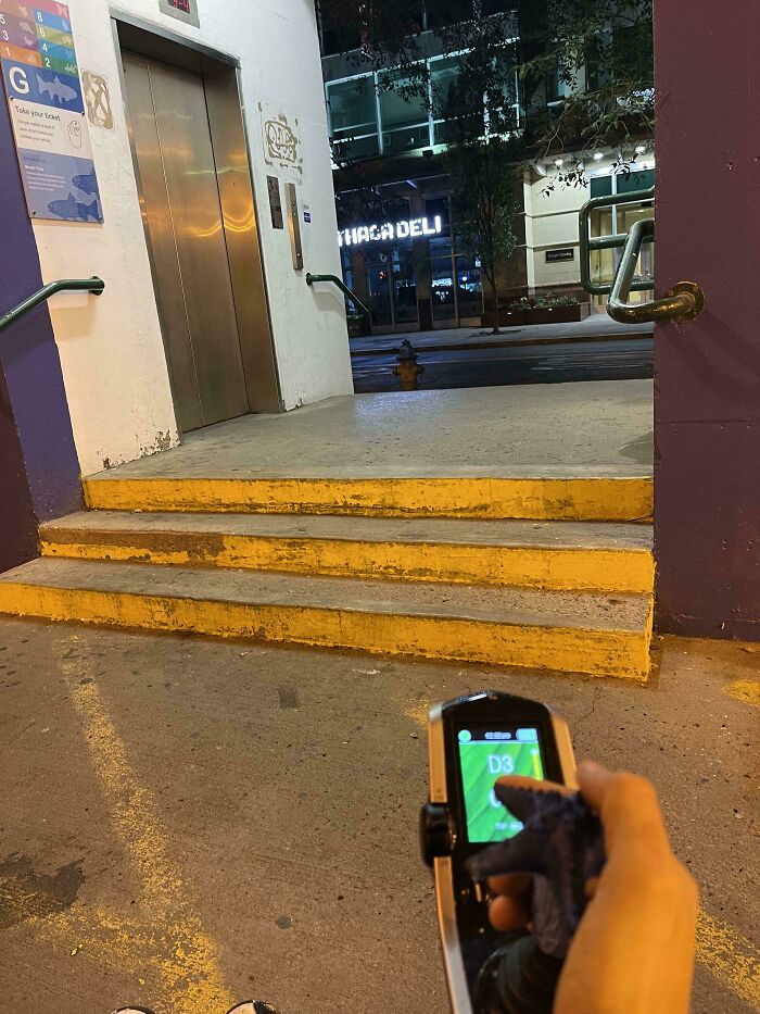 Person holding parking remote unable to access elevator due to three steps, illustrating a mildly infuriated moment.