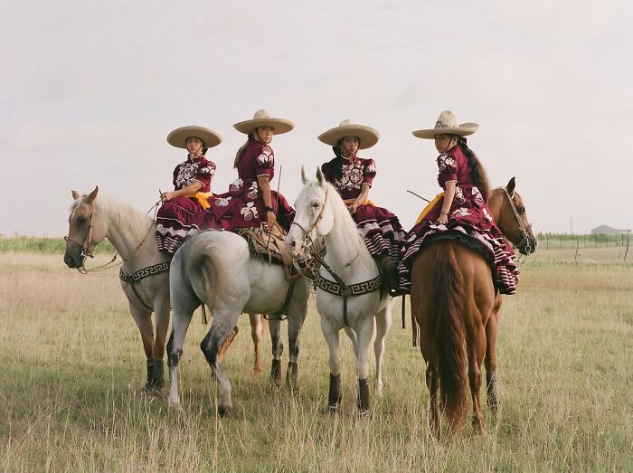 All-female rodeo riders in traditional attire on horseback showcasing the beauty and power of rodeo riding.