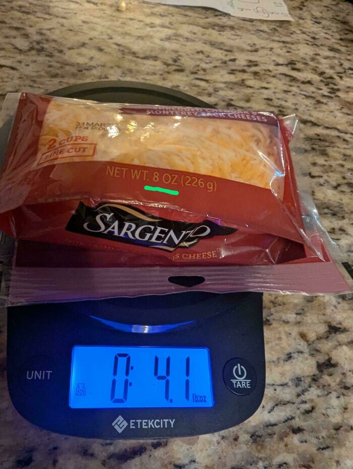 Package of shredded cheese labeled 8 oz weighed only 4.1 oz on digital scale, illustrating mildly infuriated moments.