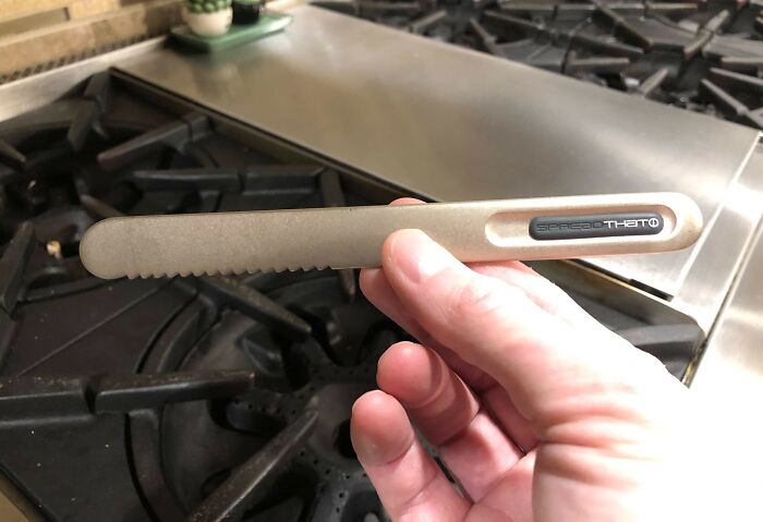 Hand holding a clever kitchen tool with serrated edge, showcasing a smart solution to common overlooked issues.