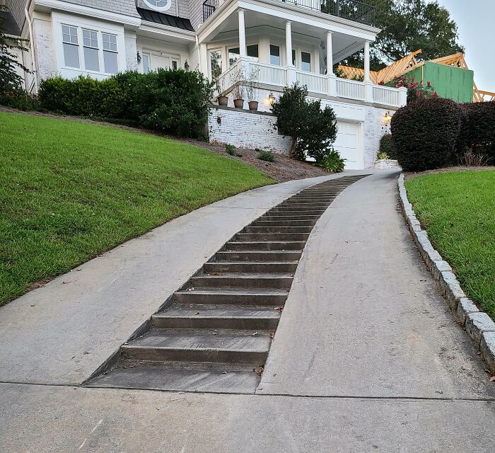 Driveway with integrated stairs in the middle providing a clever solution for accessibility on a steep slope.