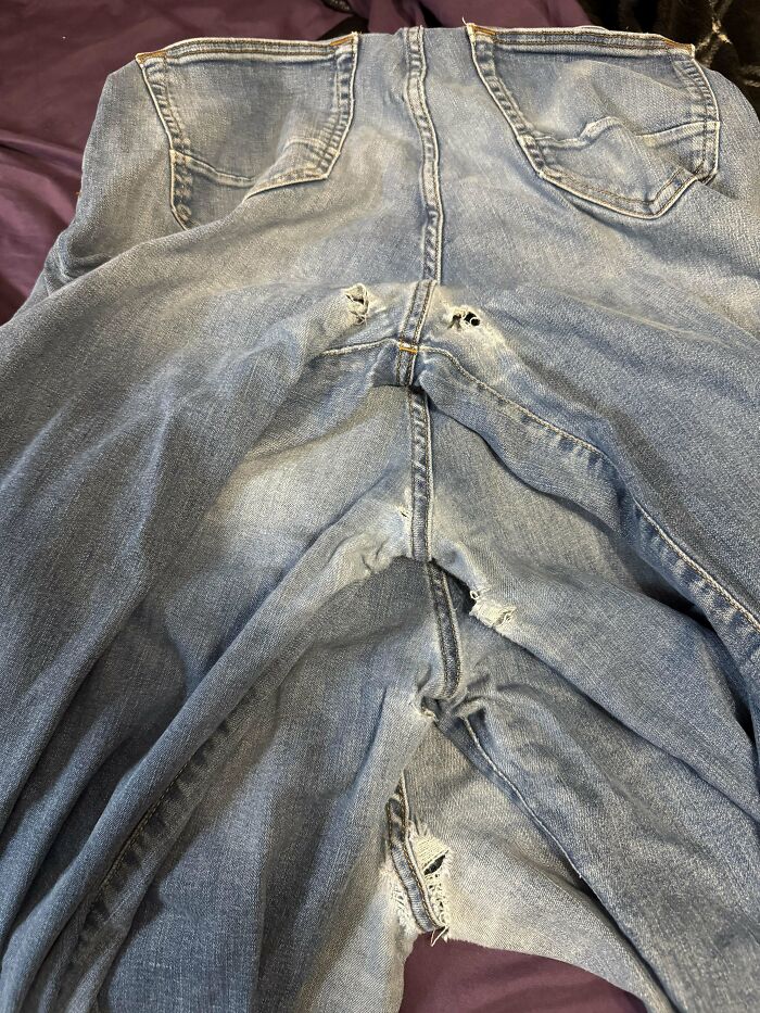 Worn-out jeans with multiple tears and holes in the c****h area, showing a common mood-ruining clothing issue.