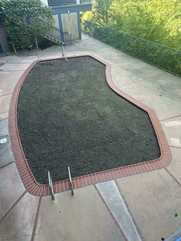 Empty pool filled with dirt and soil instead of water, a mildly infuriated scene that ruined the mood outdoors.