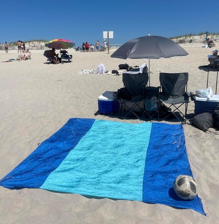 Beach setup with sunshade, camping chairs, cooler, and blanket, popular Amazon finds on wishlists this season.