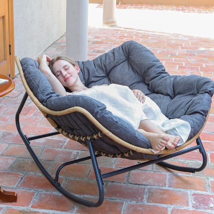 Woman relaxing in a cushioned rocking chair on a patio, one of the top Amazon finds on everyone's wishlist right now