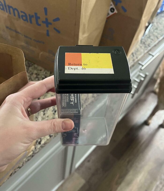 Hand holding an empty container with a return label, illustrating a mildly infuriated moment that ruined someone's mood.