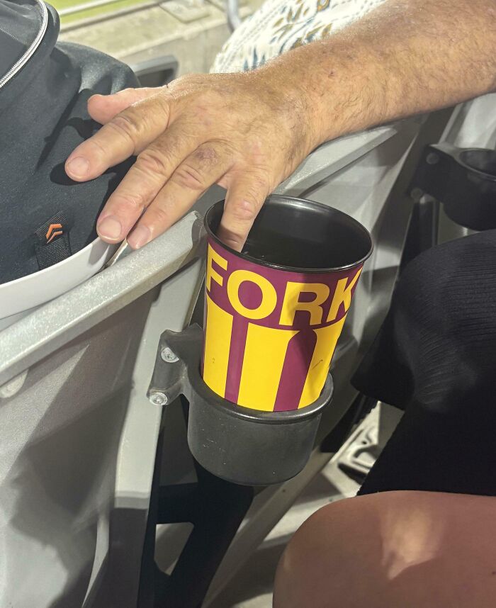 Hand resting on a cup holder with a popcorn container labeled FORK, showing a mildly infuriated mood moment.