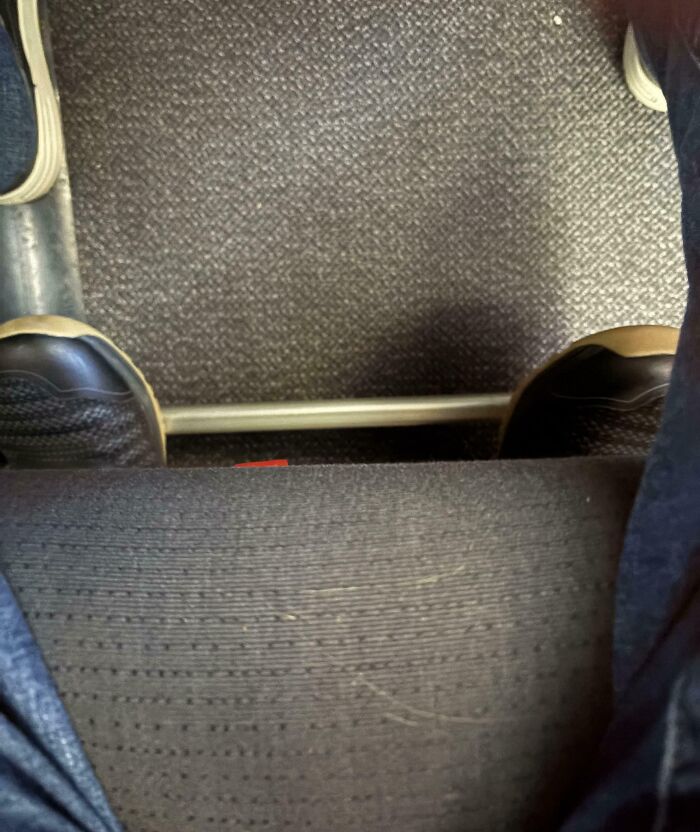 Shoes touching the back of a chair on a bus floor, illustrating a mildly infuriated moment that ruined someone's mood.