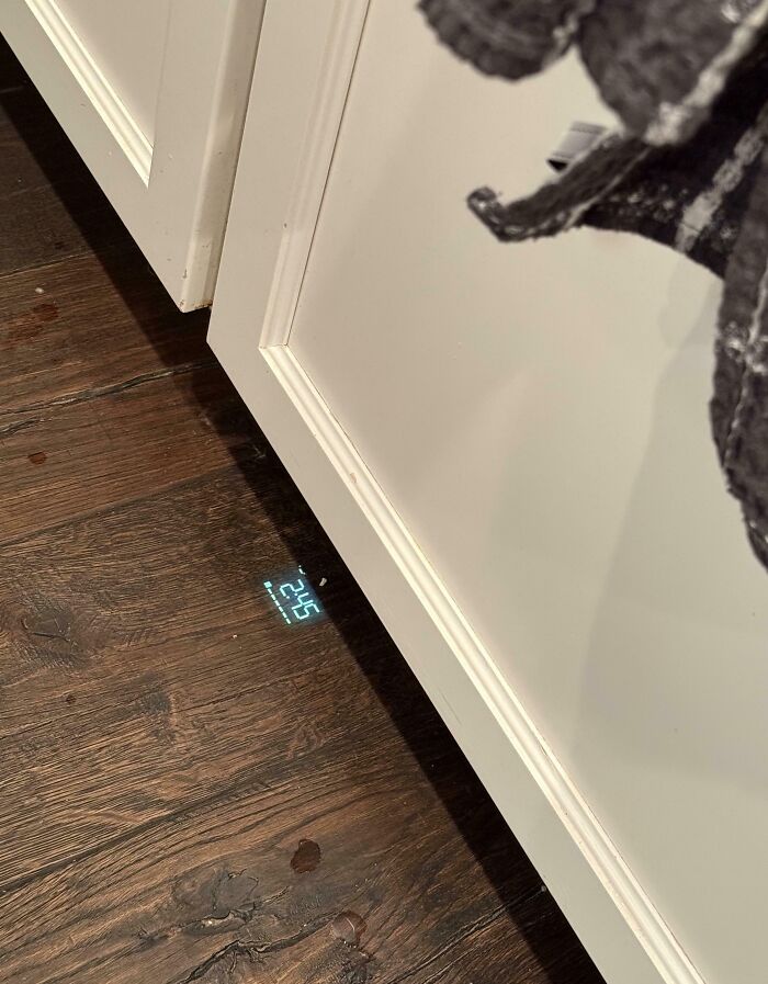 Digital scale display cleverly projected under a cabinet on wooden floor as a smart solution to overlooked space.
