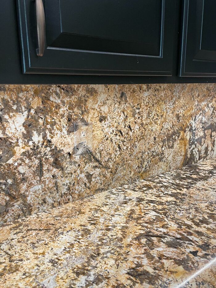 Kitchen outlet camouflaged with countertop pattern, a clever way to solve overlooked design issues creatively and seamlessly.
