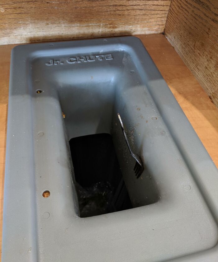 Plastic chute with a fork stuck inside shows a clever way people solved overlooked issues in everyday settings.