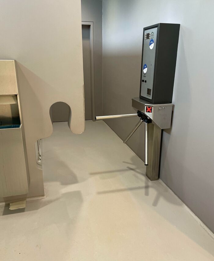 Turnstile gate modified with a lowered cutout in the wall for easy access, showcasing clever ways people solved overlooked issues.