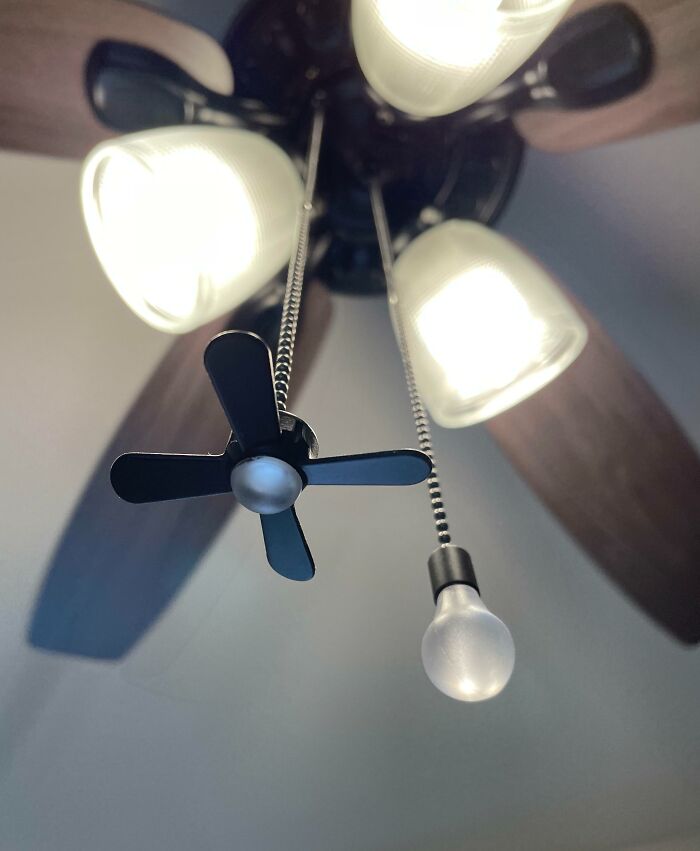 Ceiling fan pull chain with a miniature fan blade and light bulb decorations as clever solutions.