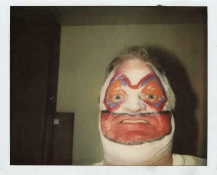 Person with colorful face paint resembling a clown, sharing a found photo with a vintage Polaroid style.