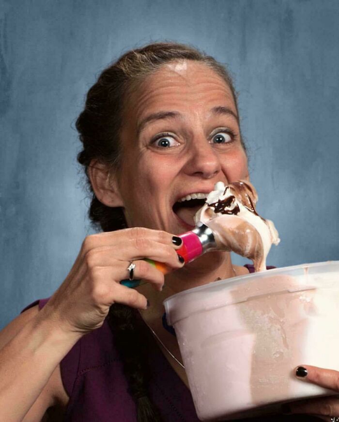 Female teacher enjoying ice cream from a large tub, showcasing love for her students and chosen teaching profession.
