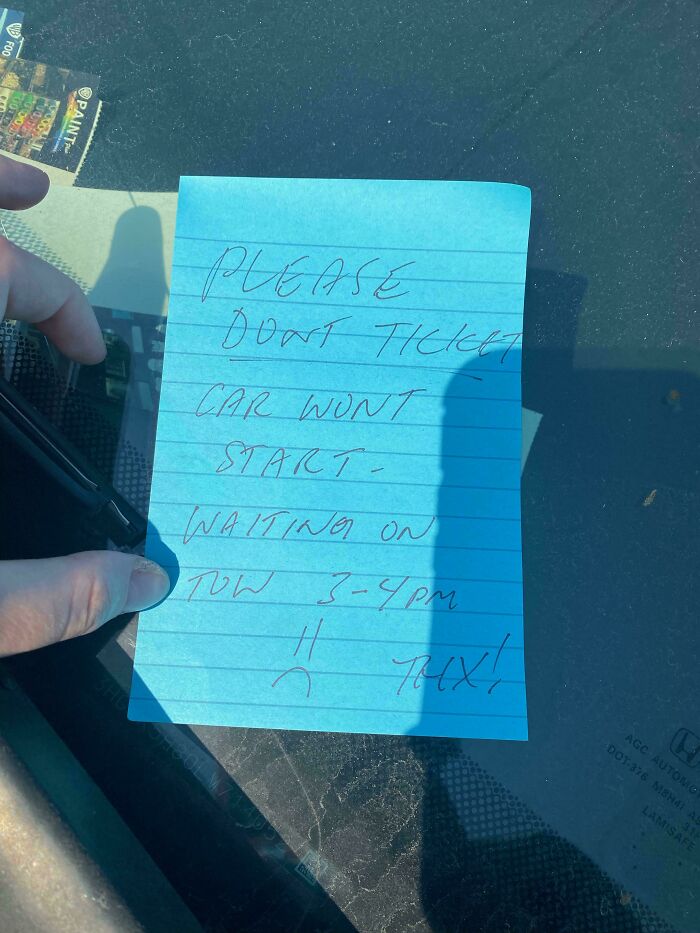 Handwritten note on car windshield asking not to ticket because the car won't start, showing chaotic good act intentions.