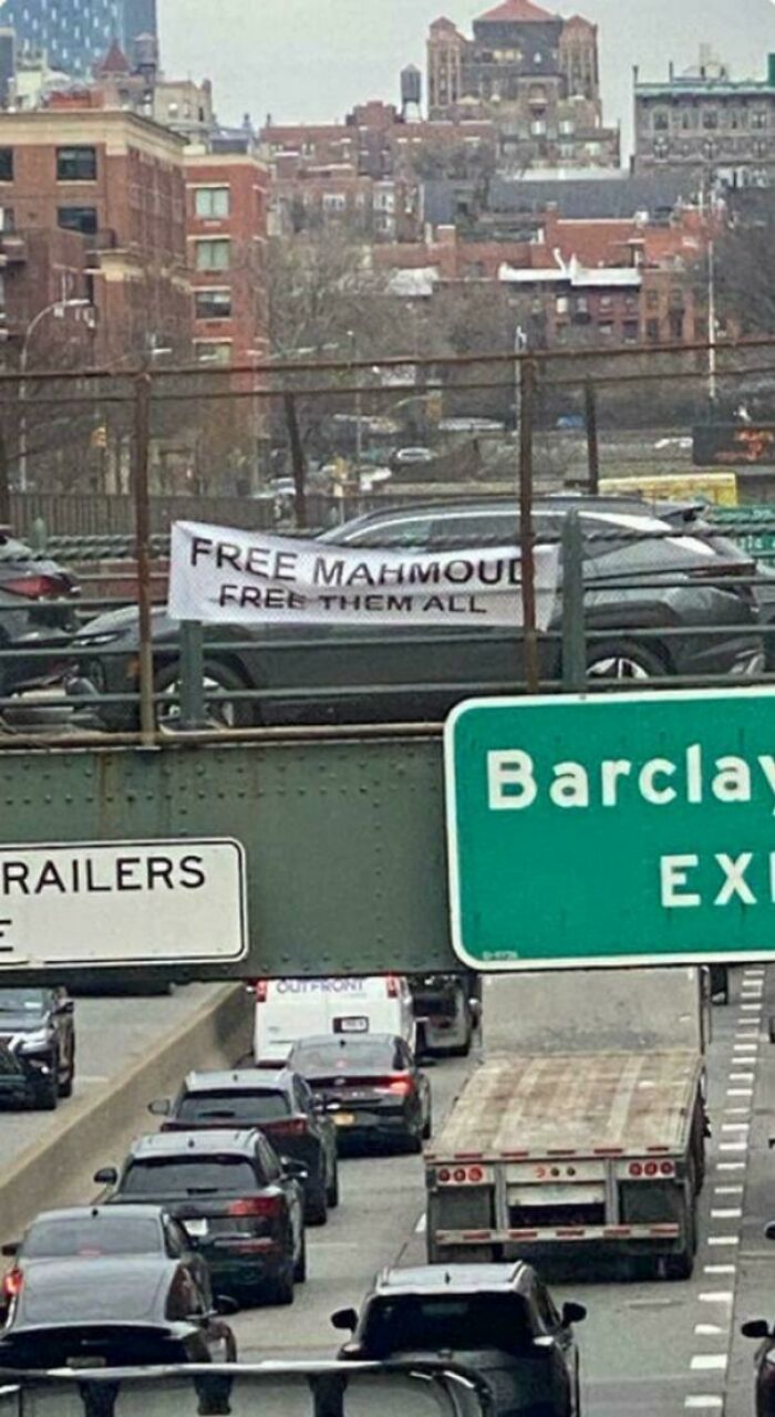 Banner with a free Mahmoud message displayed on a busy city highway, showcasing chaotic good acts with best intentions.