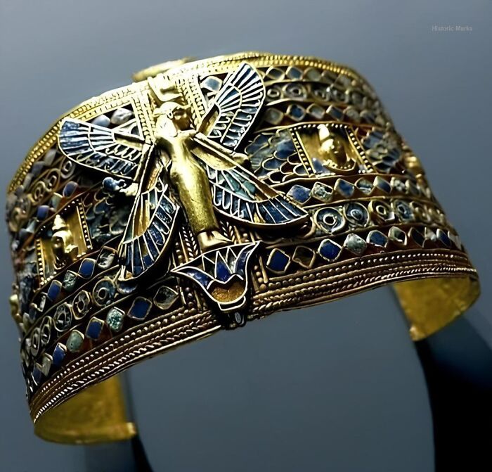 Ancient history artifact featuring detailed gold and enamel craftsmanship with winged figure and intricate designs.