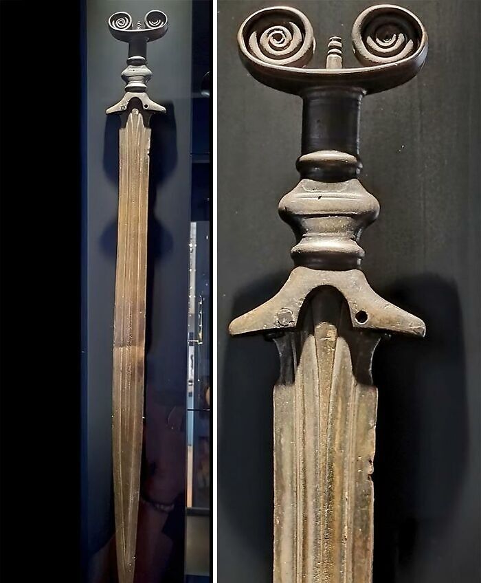 Ancient history artifact showing a detailed bronze sword with a spiral design on the hilt from old civilizations.