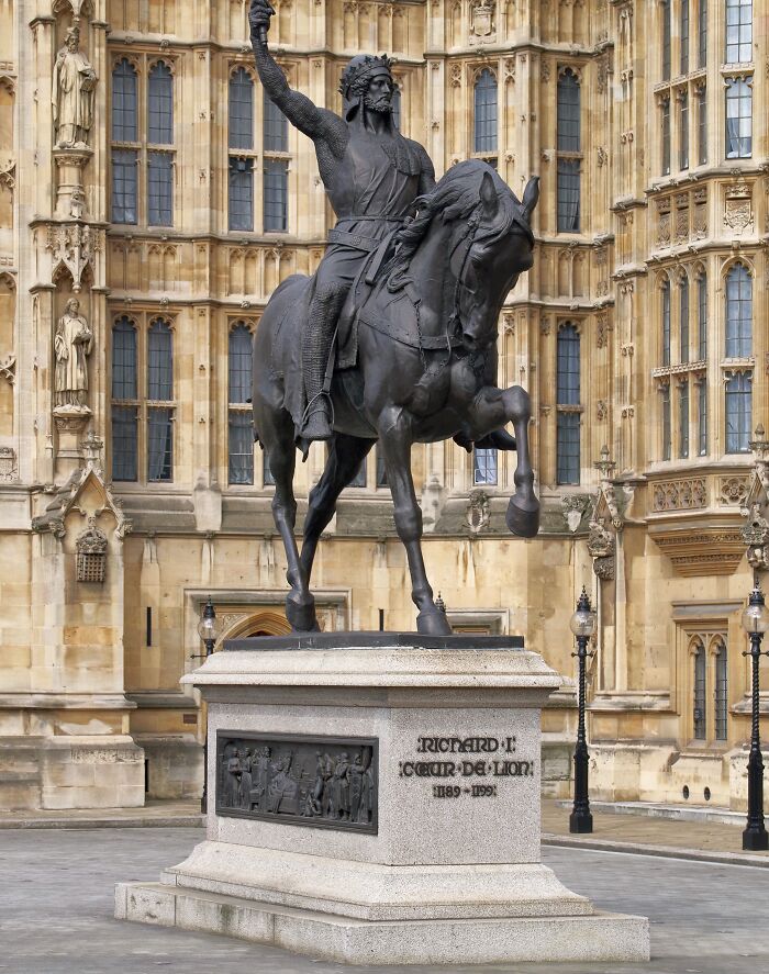 Statue of Richard the Lionheart on horseback in front of historic royal building showcasing surprising facts about royals.