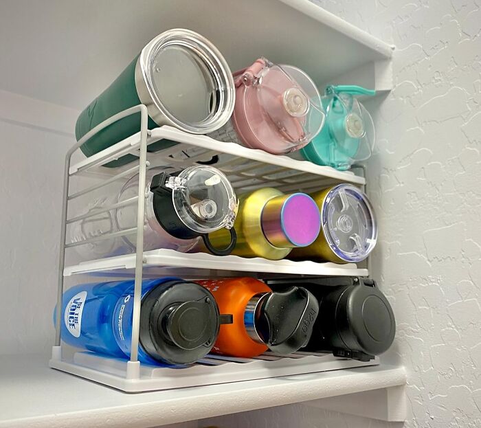 Compact kitchen storage rack organizing reusable bottles to maximize every square inch in a shoebox kitchen space.