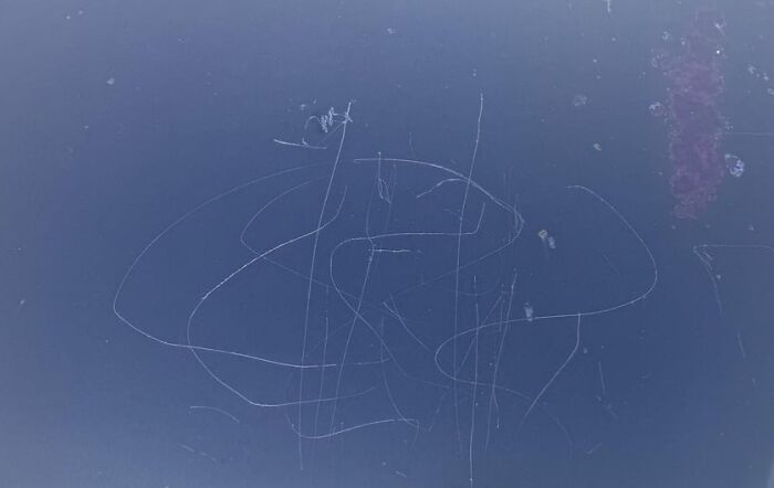 Scratches on a dark surface with faint lines and marks, evoking a chaotic and unlucky Friday the 13th vibe.