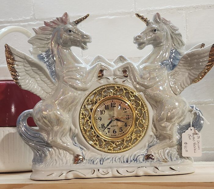 Ceramic winged unicorn clock with gold accents, a weird and wonderful thrifted find for unique collection.