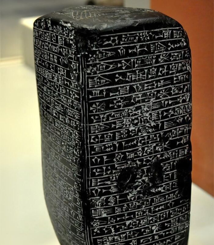 Ancient history artifact with cuneiform inscriptions on black stone, showcasing early writing from ancient civilizations.