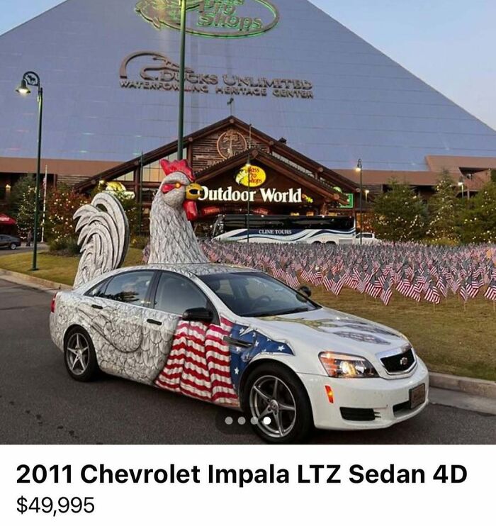 2011 Chevrolet Impala with an elaborate rooster design and American flag paint spotted for sale among chaos cars.