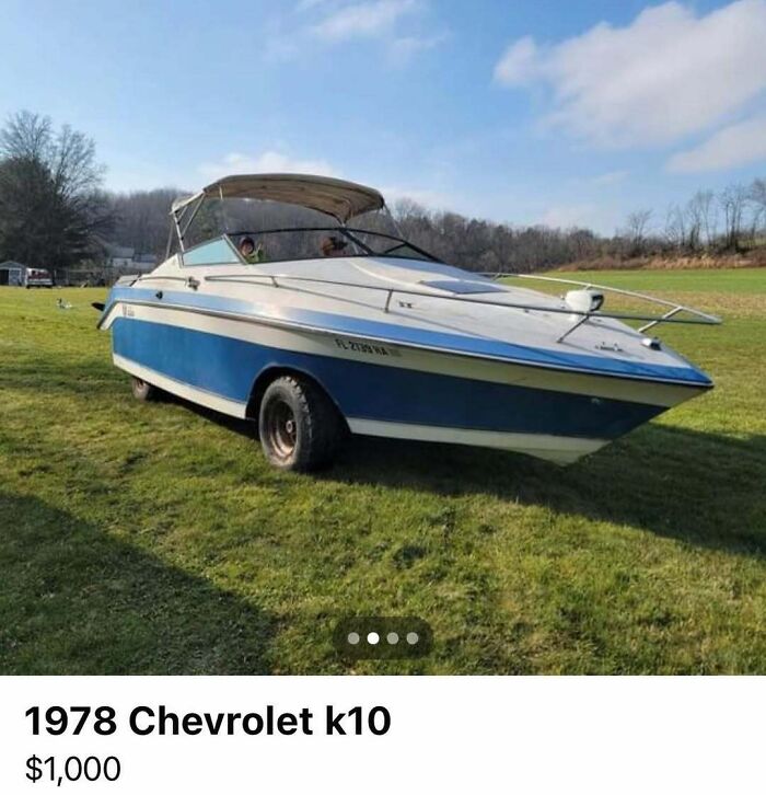 Blue and white 1978 Chevrolet k10 boat-car hybrid parked on grass in chaotic vehicle sale scene.