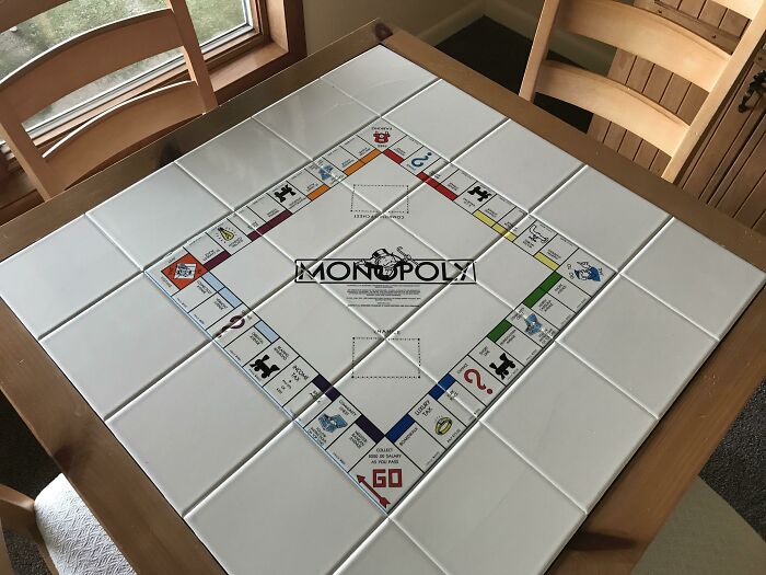 Wooden hotel table with built-in Monopoly board game tiles showcasing genius hotel design decisions.