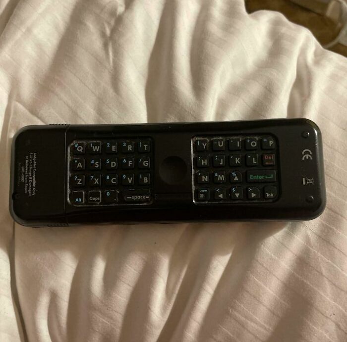 Compact hotel room remote control with built-in keyboard showcasing genius hotel design decisions for guest convenience.