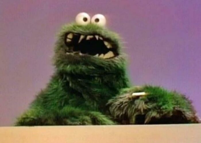 Green furry puppet with wide eyes and open mouth, showing old-fashioned puppet design that portrays how things used to look.