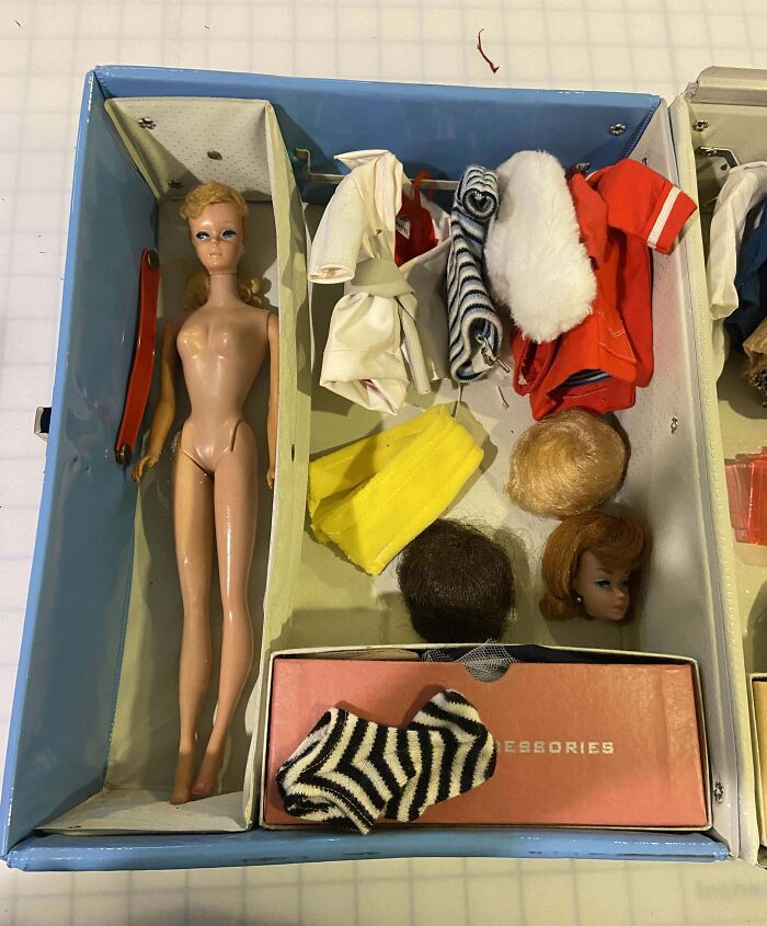 Vintage doll and clothing accessories laid out in a box, perfectly portraying how things used to look in past decades.