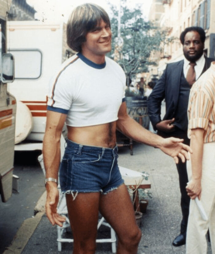 Man wearing retro cropped t-shirt and short denim shorts on street, illustrating ways things have changed through the years online.