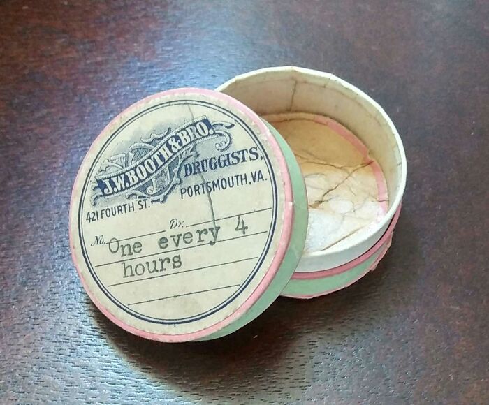 Vintage round paper pill container from J.W. Booth & Bro Druggists, illustrating how things used to look in old pharmaceutical packaging.