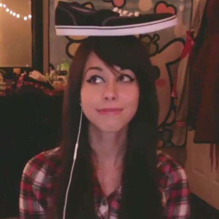 Young woman balancing a sneaker on her head, illustrating amusing ways things have changed through the years online.