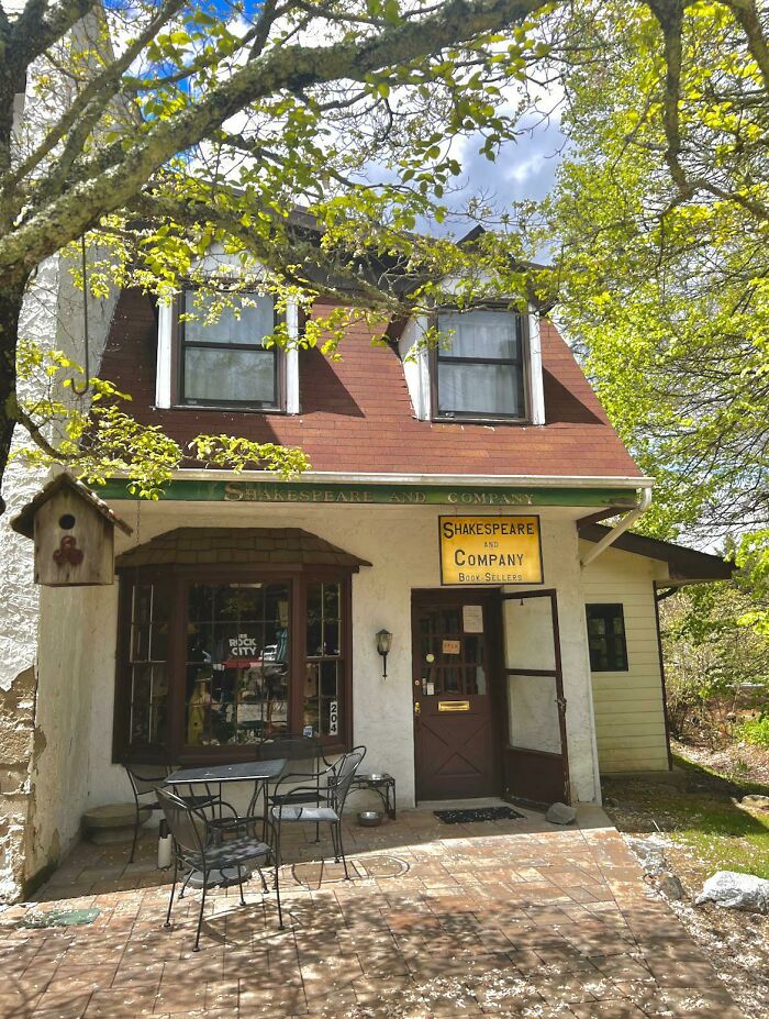 Shakespeare and Company bookstore with outdoor seating surrounded by trees showcasing stunning and impressive bookstores and libraries