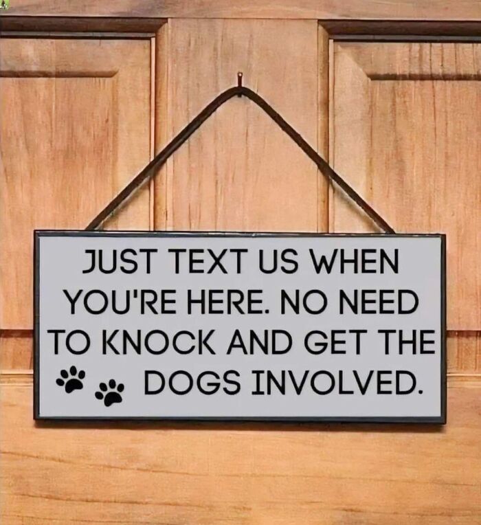 Wooden door with a hanging sign that humorously warns visitors to text instead of knocking to avoid involving dogs, doggo memes.
