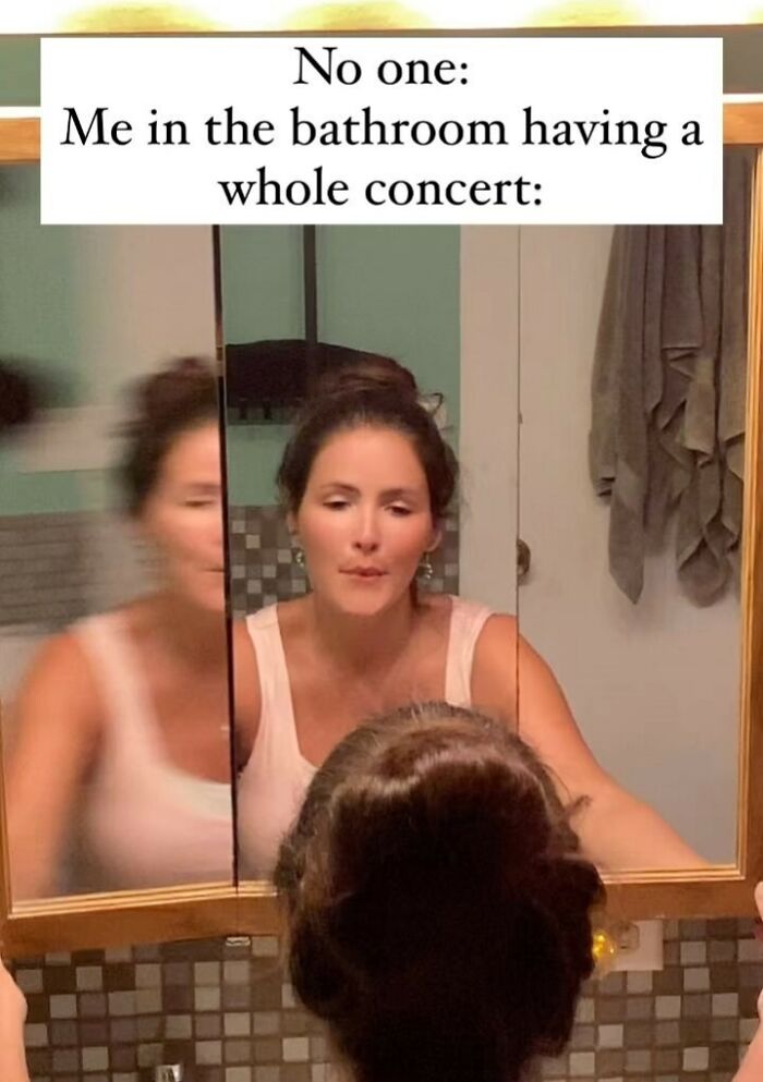 Woman looking in bathroom mirror singing with the caption about relatable memes for spamming friends with humor.