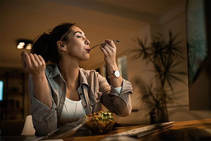 Woman enjoying food alone at home, highlighting person gets revenge on roommate stealing food off plate.