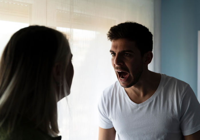 Couple having an intense argument indoors, highlighting a woman open to having kids facing relationship conflict. Couple having an intense argument indoors, highlighting a woman open to having kids facing relationship conflict.