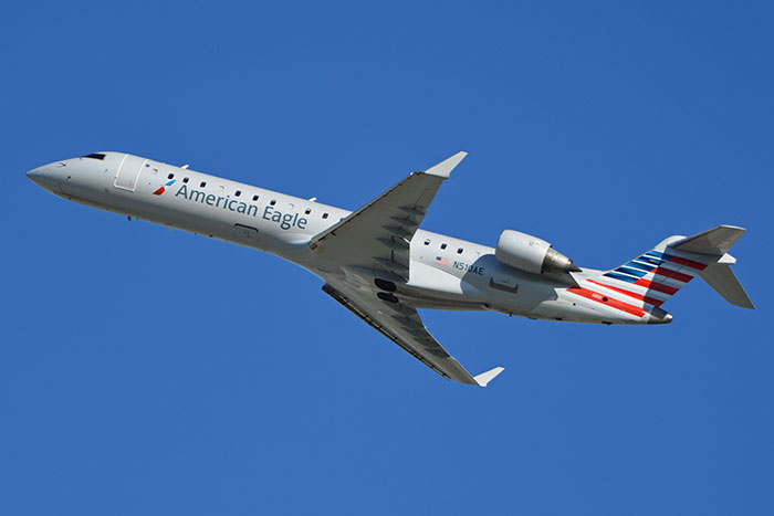 American Eagle regional jet ascending against clear blue sky moments before DC plane crash involving army pilot.