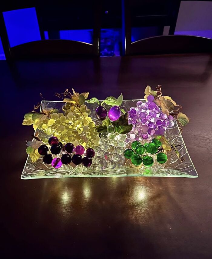 Colorful glass grape clusters arranged on a decorative tray, showcasing unique thrifted finds with a museum-worthy charm.
