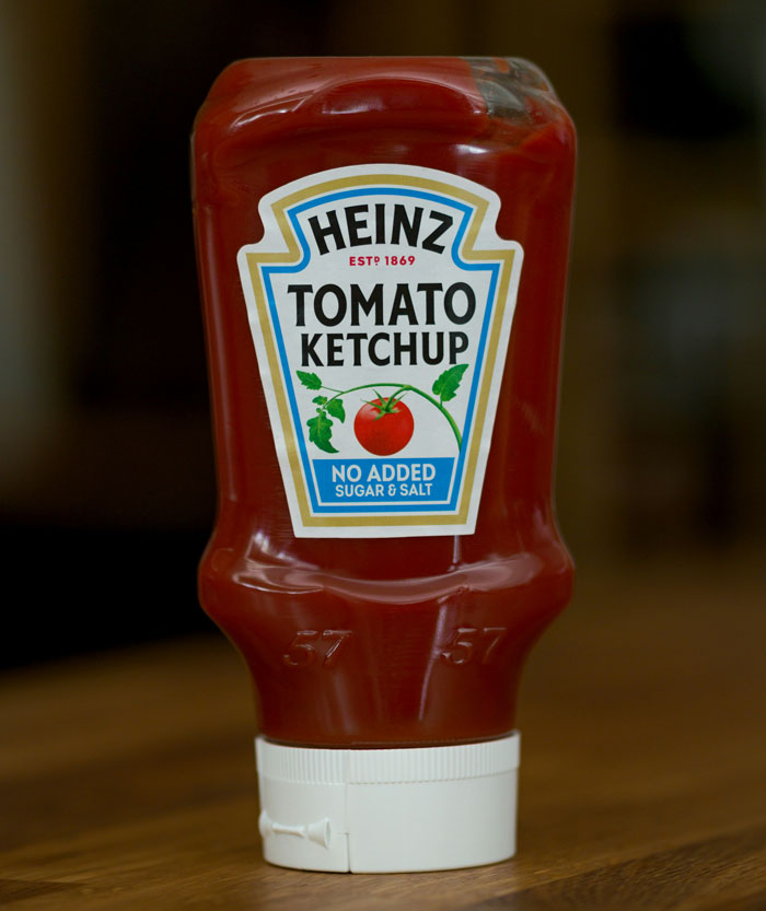 Heinz ketchup bottle on wooden table, illustrating former employees reveal disturbing workplace secrets concept.