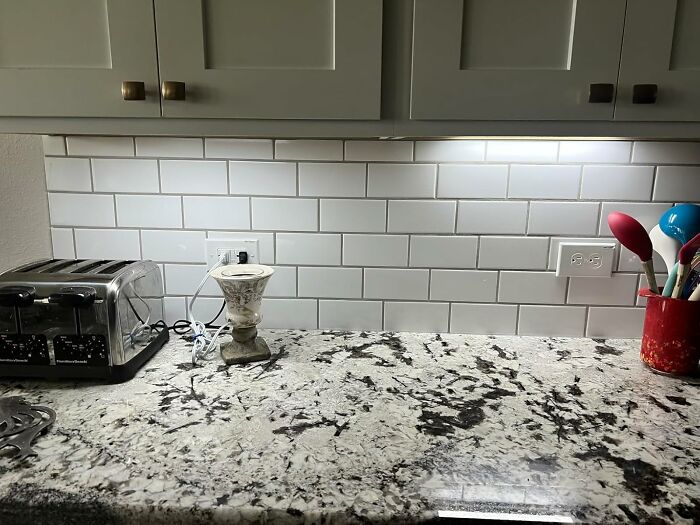 Kitchen countertop with under-cabinet lighting, subway tile backsplash, and small appliances for a kitchen glow-up.