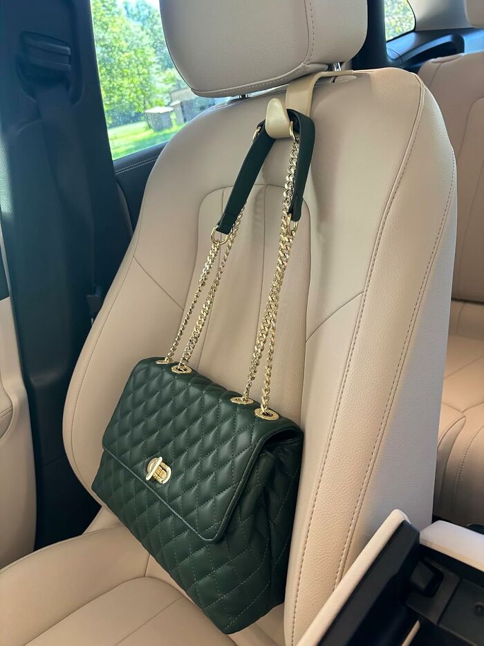 Black quilted handbag hanging from a car seat headrest, a popular Amazon find on many wishlists right now.